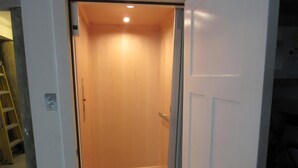 Ein Blick ins Zimmerinnere mit Holzboden, weißer Tür und einer Leuchte an der Decke.