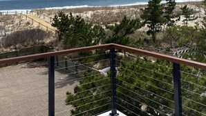 Ein Balkon mit Blick auf Strand und Meer.