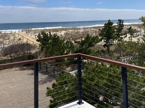 A balcony with a view of the beach and ocean. - STEPS TO OCEAN 6 Bedroom House w / elevator (Harvey Cedars)