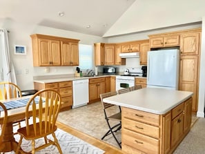 A kitchen with wooden cabinets, a white refrigerator, a microwave, and a dishwasher.