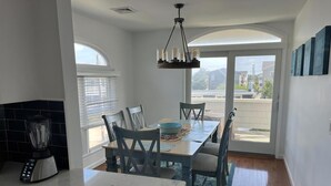 Une cuisine moderne avec un coin repas, de grandes fenêtres et une vue sur la ville.