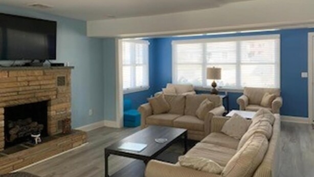 A living room with a fireplace, a sofa set, a coffee table, and a television. - Short walk to Ocean-great for large family (Beach Haven Terrace)