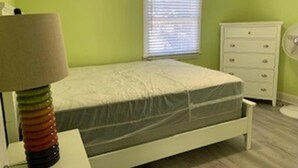 A bedroom with a bed, a dresser, a lamp, and a window with blinds. - Short walk to Ocean-great for large family (Beach Haven Terrace)