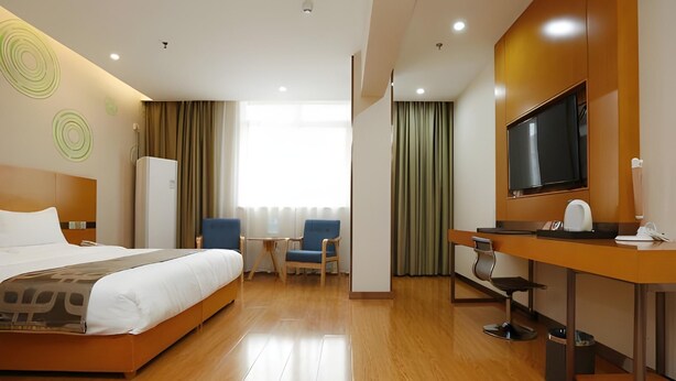 A hotel room with a bed, a desk with a TV, a chair, and a window with curtains. - Greentree Inn Xi an Ming City Wall Northwest Dafengqing Road Business Hotel (Xi'an)