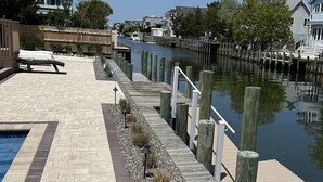 A waterfront patio with a pool, wooden deck, and a view of the water. - 4 bedroom accommodation in Loveladies (Loveladies)