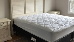A bedroom with a bed, nightstands, a dresser, a window, and a ceiling fan.