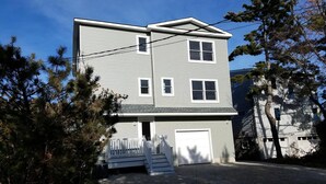 A two-story building with a front porch, a garage, and a driveway.