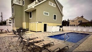 A two-story building with a swimming pool, outdoor seating, and a fenced patio area. - 220 12th St Associates, LLC (Beach Haven)