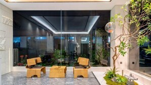 A modern interior with three wooden chairs and a glass partition. - Yin E Hotel (Emeishan City)
