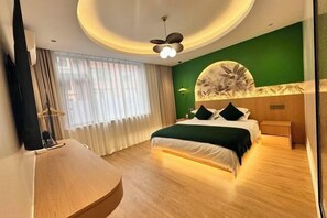 Ein modernes Hotelzimmer mit einem Bett, einem Schreibtisch, einem Fernseher und einem großen Fenster mit Vorhängen.