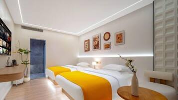 Una habitación de hotel moderna con dos camas, una mesita, un escritorio y un estante en la pared.