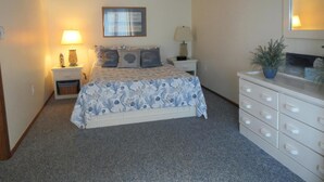 A bedroom with a bed, bedside tables, a dresser, a ceiling fan, and an air conditioning unit. - Nice townhouse style condo with pool in Brant Beach. Unit overlooks pool and. (Brant Beach)
