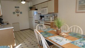 A kitchen with a microwave, refrigerator, and a dining table with chairs. - Nice townhouse style condo with pool in Brant Beach. Unit overlooks pool and. (Brant Beach)