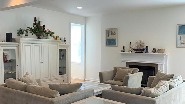 Un salon moderne avec deux canapés gris, une table basse blanche et une cheminée.