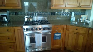 A kitchen with wooden cabinets, a stainless steel stove, and a built-in oven.