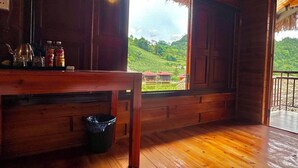 A wooden interior with a window overlooking a green landscape. - Bac Ha Lodge Reatreat (Bac Ha)