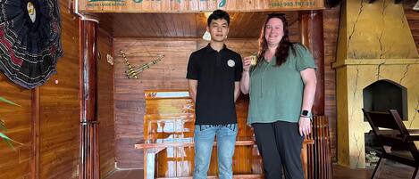 Un interior de madera con un letrero que dice 'Bac Ha Logde Retreat' y un número de contacto.