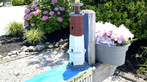 En model af et fyrtårn med et skilt, der viser 'New Jersey Barnegat Light', og en blomsterpotte.