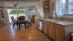 A kitchen with wooden cabinets, a dishwasher, and a large window.