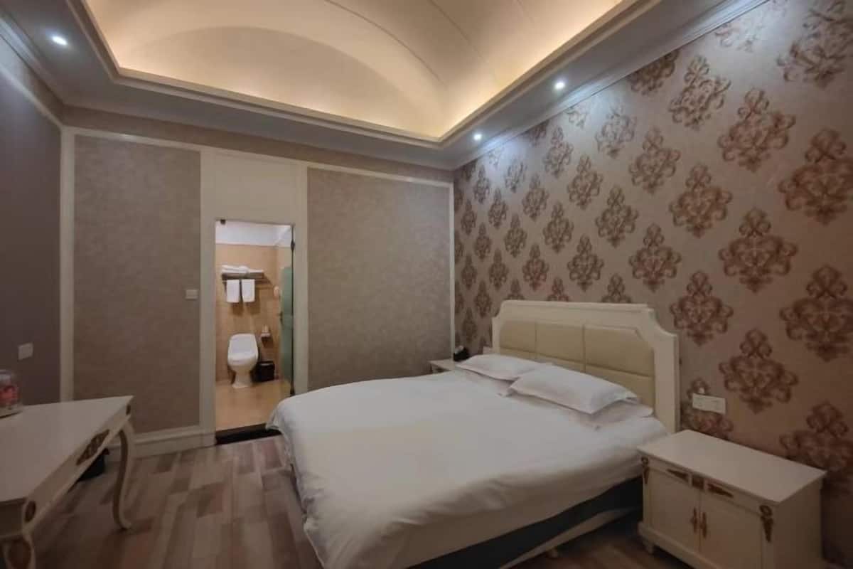 A bedroom with a bed, bedside table, and a wardrobe.
