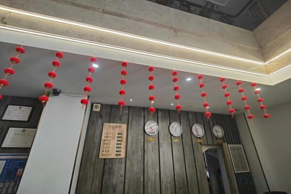Una habitación con paredes de paneles de madera, un reloj y un calendario colgado en la pared.