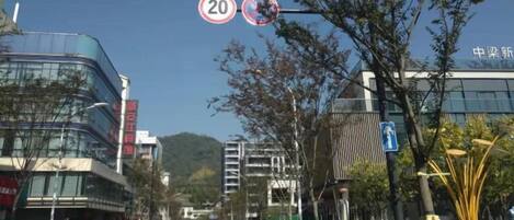 A street with buildings, cars, and a speed limit sign.