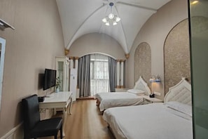 A hotel room with two beds, a desk with a chair, a TV, and a ceiling fan. - Xin'anjiang Hotel (Jiande)