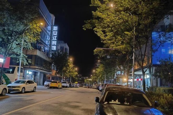 A nighttime street scene with parked cars and illuminated buildings. - Xin'anjiang Hotel (Jiande)