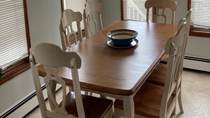 Ein Esszimmer mit Holztisch, sechs Stühlen und einem Deckenventilator.