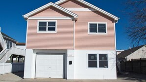 A two-story house with a white garage door, a small porch, and a visible number "111".