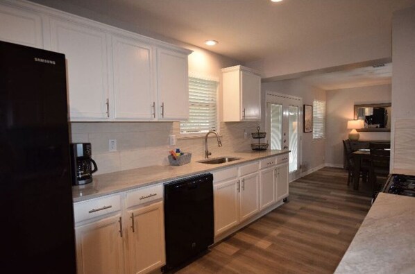 Enjoy cooking in this well-equipped kitchen with a dishwasher, sink, and coffee maker.