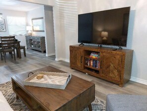 Relax in this stylish living room with a flat-screen TV, comfortable sofa, and dining area.