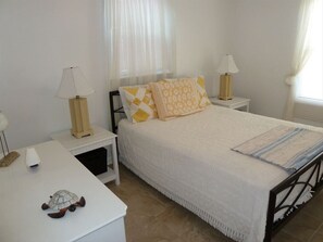 Cozy retreat with a single bed, bedside tables, and sheer curtains.