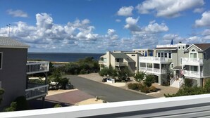 A coastal residential area with beachfront properties, including a two-story house with a balcony and a one-story house with a porch. - 4 bedroom accommodation in North Beach (North Beach)