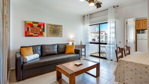 Una sala de estar moderna con un sofá, una mesa de centro y una obra de arte en la pared.