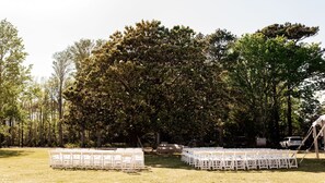 An outdoor event space with rows of white chairs arranged for seating.