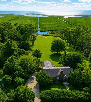 Ein Haus, umgeben von üppiger Vegetation und einem Wasserlauf.