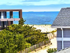 Une propriété située sur la côte, avec vue sur la mer, un bâtiment moderne et une clôture en bois.