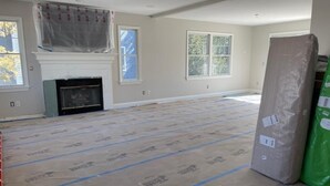 A room with a fireplace, large windows, and insulation on the floor. - 5 bedroom accommodation in Long Beach Township (Long Beach Township)