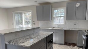 A kitchen with grey cabinets, a granite countertop, and a window. - 5 bedroom accommodation in Long Beach Township (Long Beach Township)