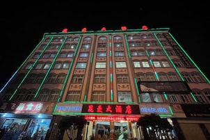 A multi-story hotel with illuminated signage and a prominent entrance.