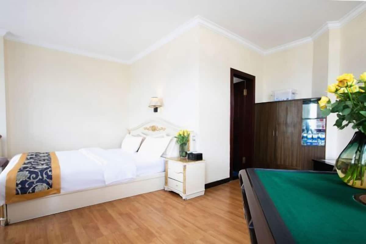 Une chambre d’hôtel avec un lit, une table de chevet, une lampe et un billard vert.