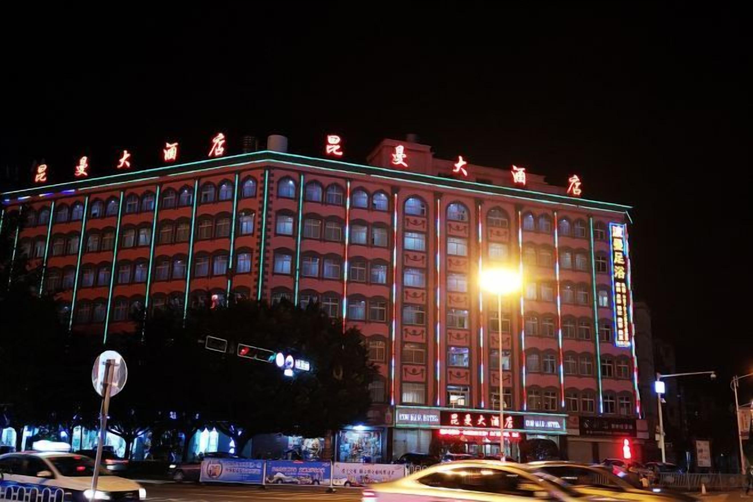 Un hotel de varios pisos con fachada roja y señalización iluminada.