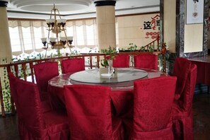 A round table with chairs, a vase with a flower, and a chandelier. - Pu'er Kunman Hotel (Pu'er)