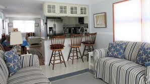 A living room with a sofa, chairs, and a dining area with a table and chairs.