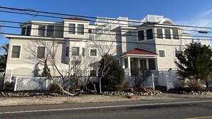 Une maison à deux étages avec un porche à l’avant, un garage et une allée.