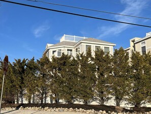 Um edifício de dois andares com fachada branca e uma varanda.