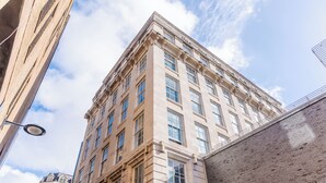 Een hoog, historisch gebouw met veel ramen en een klassieke architectuur.