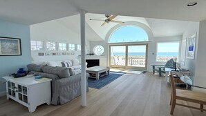 A spacious living room with a large window, a ceiling fan, and a view of the beach. - 3 bedroom accommodation in Holgate (Holgate)