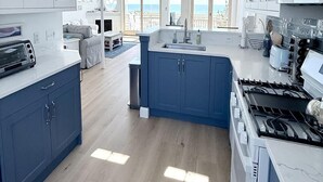 A spacious kitchen with a central island, a ceiling fan, and a view to the outside. - 3 bedroom accommodation in Holgate (Holgate)